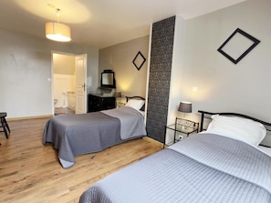 A hotel room with two beds, a dresser, a mirror, a nightstand, and a lamp. - Spacious house near Flemish Hills - 14 guests (Méteren)