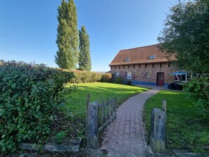 A brick house with a red-tiled roof, a paved pathway leading to the entrance, and a well-maintained lawn. - Spacious house near Flemish Hills - 14 guests (Méteren)