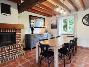 A dining area with a brick fireplace, wooden ceiling beams, and a large window with a view of greenery. - Spacious house near Flemish Hills - 14 guests (Méteren)
