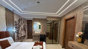 A modern hotel room with a large bed, a bathroom with a mirror, and a desk with a vase. - city plaza pyramid view (Giza)