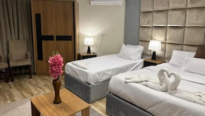 A hotel room with two beds, a wooden wardrobe, a desk with a vase, and a wall-mounted air conditioner. - city plaza pyramid view (Giza)