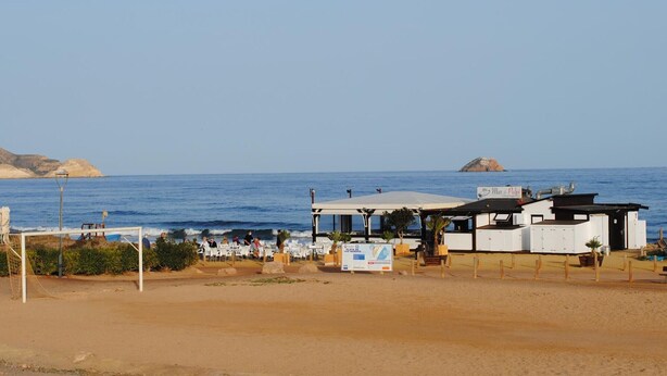 Un restaurante frente a la playa con terraza y vistas al mar.