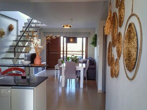 Eine moderne Küche mit Essbereich, einer Treppe und einem Wohnzimmer mit Sofa und Couchtisch.