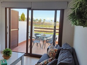 A room with a sliding glass door leading to an outdoor patio with a table and chairs. - Charming apartment in San Juan de los Terreros with communal pool and WiFi (San Juan de los Terreros)