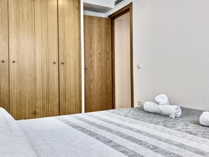 Habitació d'hotel amb un llit, un armari de fusta i una porta de bany.