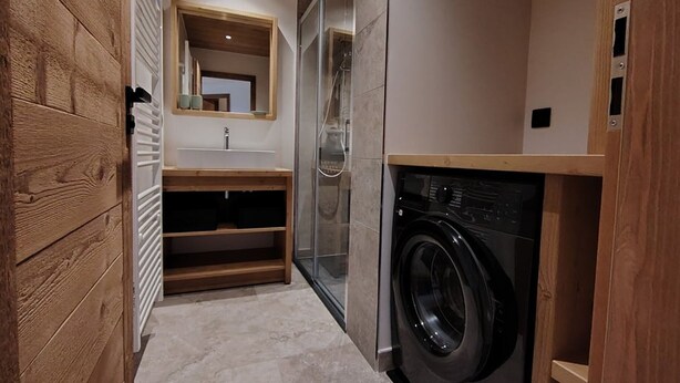 A compact laundry room with a washing machine, a sink, and a mirror. - Charming apartment at the foot of the slopes - 5 guests (Crest-Voland)