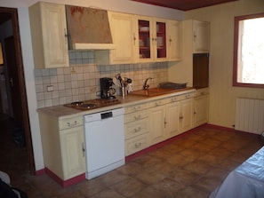 A compact kitchen with white cabinets, a dishwasher, and a window. - Chalet in center, 12 guests (Arâches-la-Frasse)