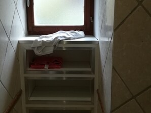 A small, enclosed space with a window, a white shelf with a white cloth and a red cloth, and a tiled wall. - Chalet in center, 12 guests (Arâches-la-Frasse)