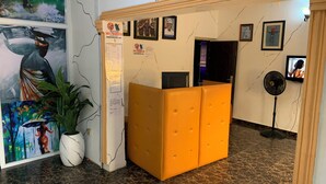 A reception area with a marble floor, a reception desk, and a wall with framed pictures and a notice board. - Diamond Groove Hotel & Suites (Sangotedo)