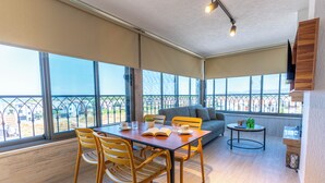 A spacious balcony with a dining area, a sofa, and a small table with drinks. - ARVIA SUITES (Altinova)