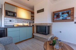 A modern kitchen with a built-in microwave, a sink, and a stove. - ARVIA SUITES (Altinova)