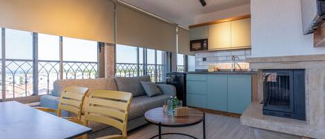 Una sala de estar moderna con sofá, sillas, una mesa de comedor y una zona de cocina con microondas.