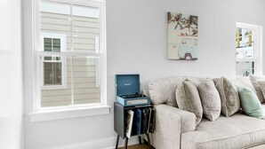 A living room with a light-colored sofa, a side table with a record player, and a wall-mounted painting. - Swell House-2.5 Blocks to Ocean-Pet Friendly (Myrtle Beach)