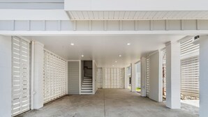 A covered outdoor corridor with a staircase leading to an upper level, enclosed by white paneling. - Swell House-2.5 Blocks to Ocean-Pet Friendly (Myrtle Beach)