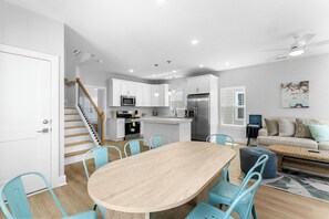 A modern kitchen with white cabinets, a central island, and stainless steel appliances. - Swell House 2.5 Blocks to Ocean Pet Friendly (Myrtle Beach)