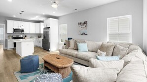 A modern kitchen with white cabinets, a central island, and a dining area. - Swell House-2.5 Blocks to Ocean-Pet Friendly (Myrtle Beach)