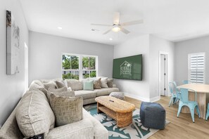 A modern living room with a sofa, coffee table, and dining area. - Swell House 2.5 Blocks to Ocean Pet Friendly (Myrtle Beach)