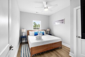 A bedroom with a bed, a ceiling fan, a window, a nightstand, and a wall-mounted shelf. - Swell House 2.5 Blocks to Ocean Pet Friendly (Myrtle Beach)