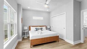 A bedroom with a large bed, a ceiling fan, and a view of the outside. - Swell House-2.5 Blocks to Ocean-Pet Friendly (Myrtle Beach)