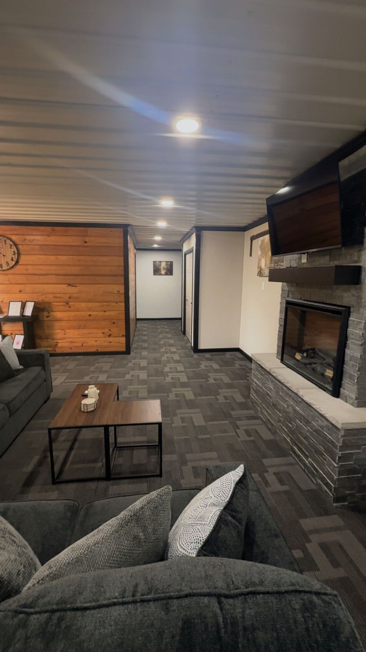 A living room with a fireplace, a sofa, a coffee table, and a patterned floor.