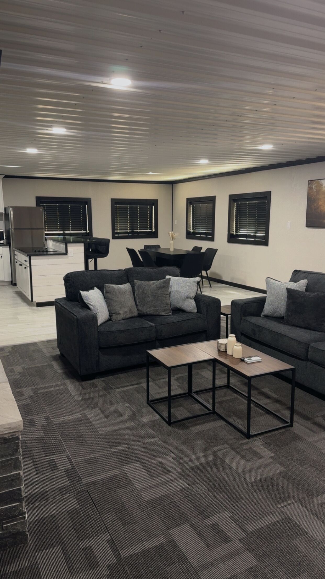 Un salon moderne avec deux canapés, une table basse et un coin repas comprenant une table et des chaises.