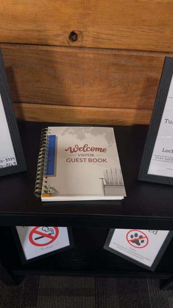 A welcome guest book on a wooden shelf.