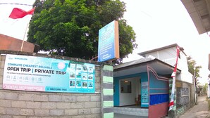 A building with a signboard advertising a rental motorcycle service.