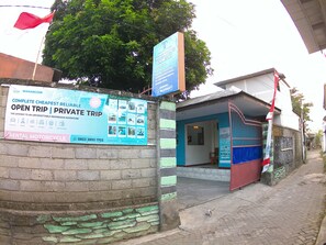 A building with a signboard advertising a rental motorcycle service.