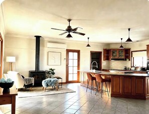 A spacious kitchen with a central island, wooden cabinets, and a built-in stove.