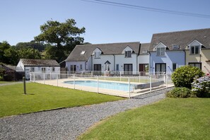 Uma área residencial com piscina, casas e gramado.