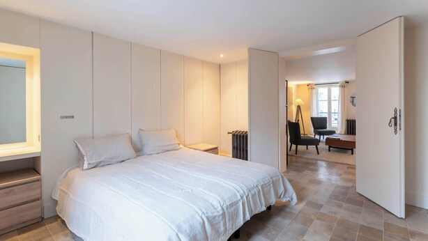 A bedroom with a large bed, a desk, and a chair. - 2BDR 2 Bath Rare Saint Germain des Pres (Paris)