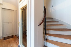Eine Treppe mit Holzdielen und einem Metallgeländer, die zu einer oberen Etage führt.