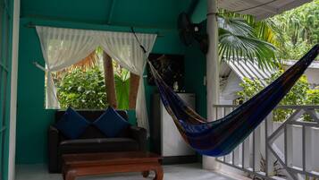 A room with a hammock, a sofa, and a bench.