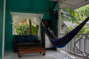 Una habitación con una hamaca, un sofá y un banco.