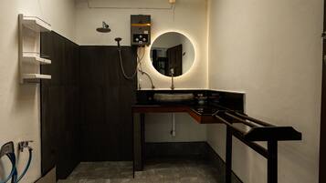 A bathroom with a shower, a sink, and a mirror.