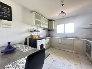 A compact kitchen with a washing machine, a sink, and a window. - Detached Apartment in Saint-Raphaël (Saint-Raphaël)