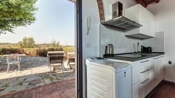 A kitchen with a built-in stove, a coffee maker, and a view of the outdoors.