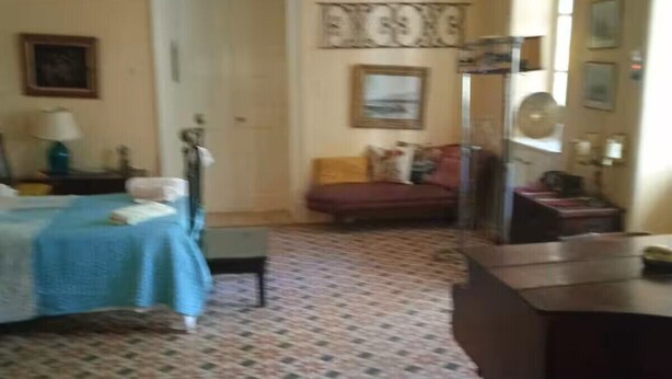 A room with a bed, a desk, a chair, a sofa, and a patterned floor. - Delightful 3-bedroom cottage with AC in Zakynthos (zakynthos)