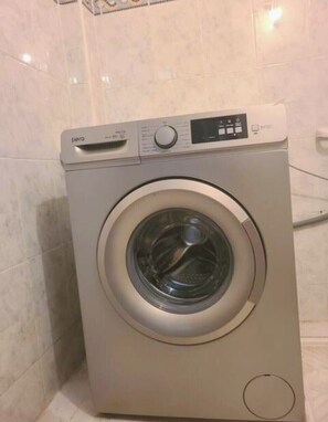 A front-loading washing machine in a bathroom with tiled walls. - House with Private Terrace and Pool in a Quiet Location, 10 Minutes from the Medina (Fès)