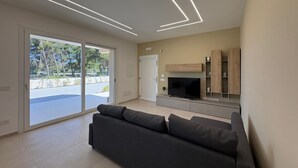 Een moderne woonkamer met een bank, televisie en inbouwplanken.