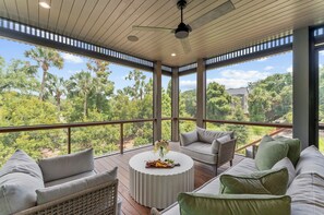 A spacious balcony with a view of lush greenery and a modern outdoor seating area. - Brand new build in new Ocean Park area (Kiawah Island)