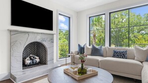 Un salon moderne avec une cheminée, une grande fenêtre et un canapé.