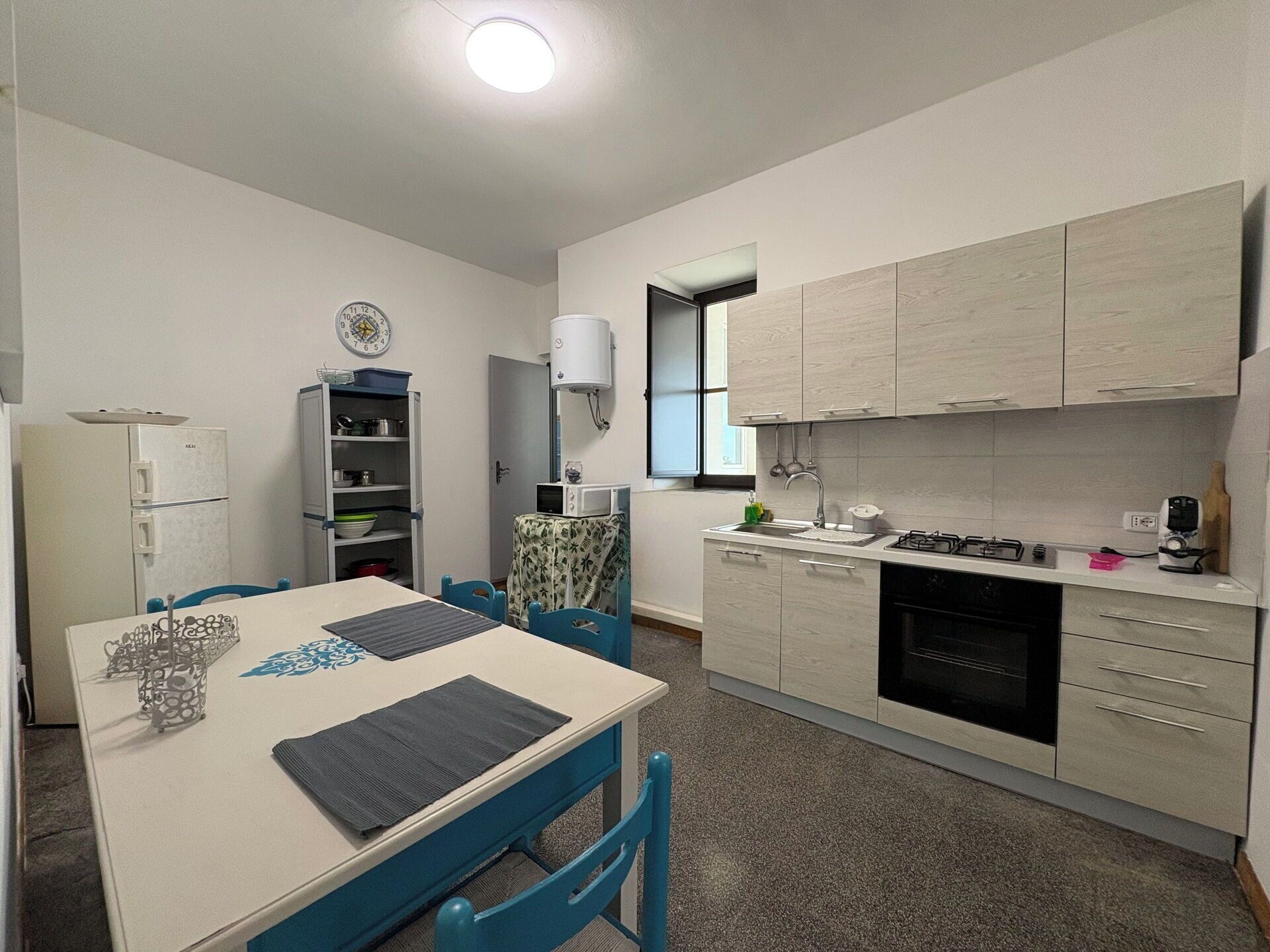 Una cocina compacta con comedor, refrigerador, microondas y estufa.