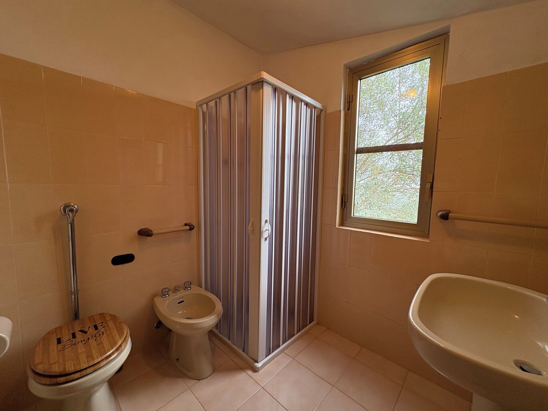 A bathroom with a toilet, bidet, and a shower enclosure.