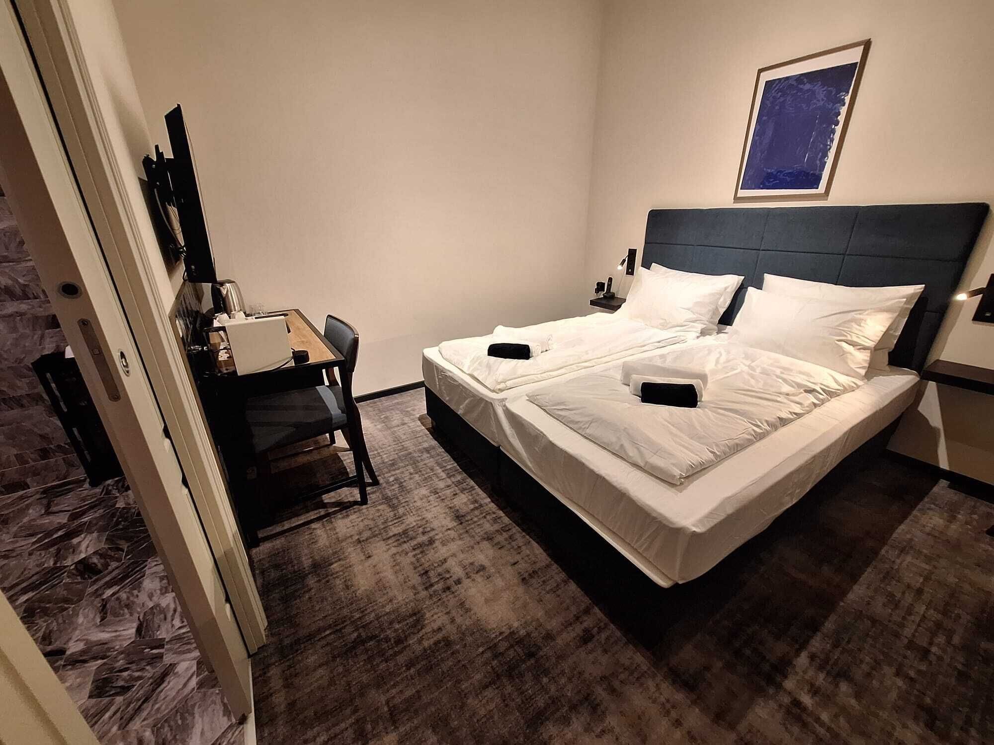 Ein Hotelzimmer mit Bett, Schreibtisch und Stuhl.