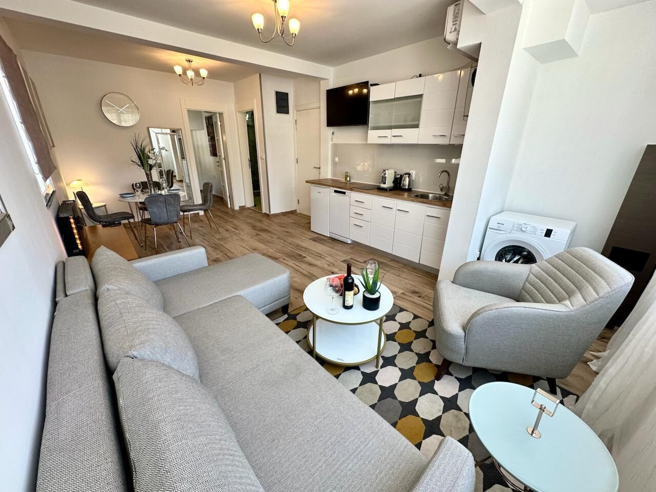 Una sala de estar moderna con un sofá, sillones, una mesa de centro y un comedor.