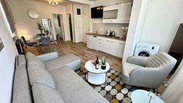 A modern living room with a sofa, armchairs, a coffee table, and a dining area.