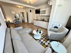 Una sala de estar moderna con un sofá, sillones, una mesa de centro y un comedor.