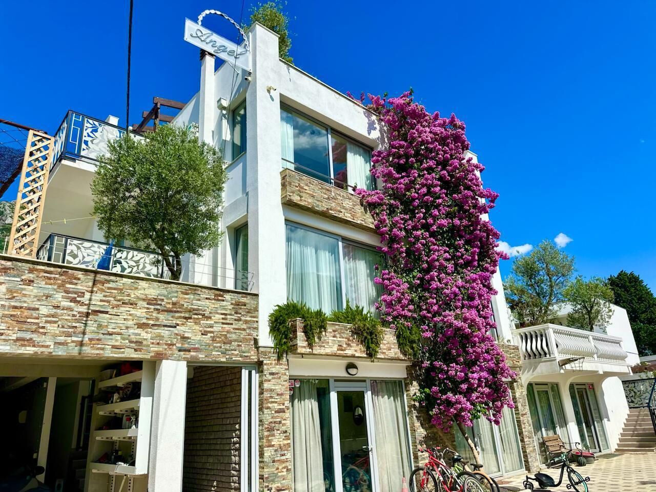 A two-story building with a balcony, a staircase, and a bike parked outside.