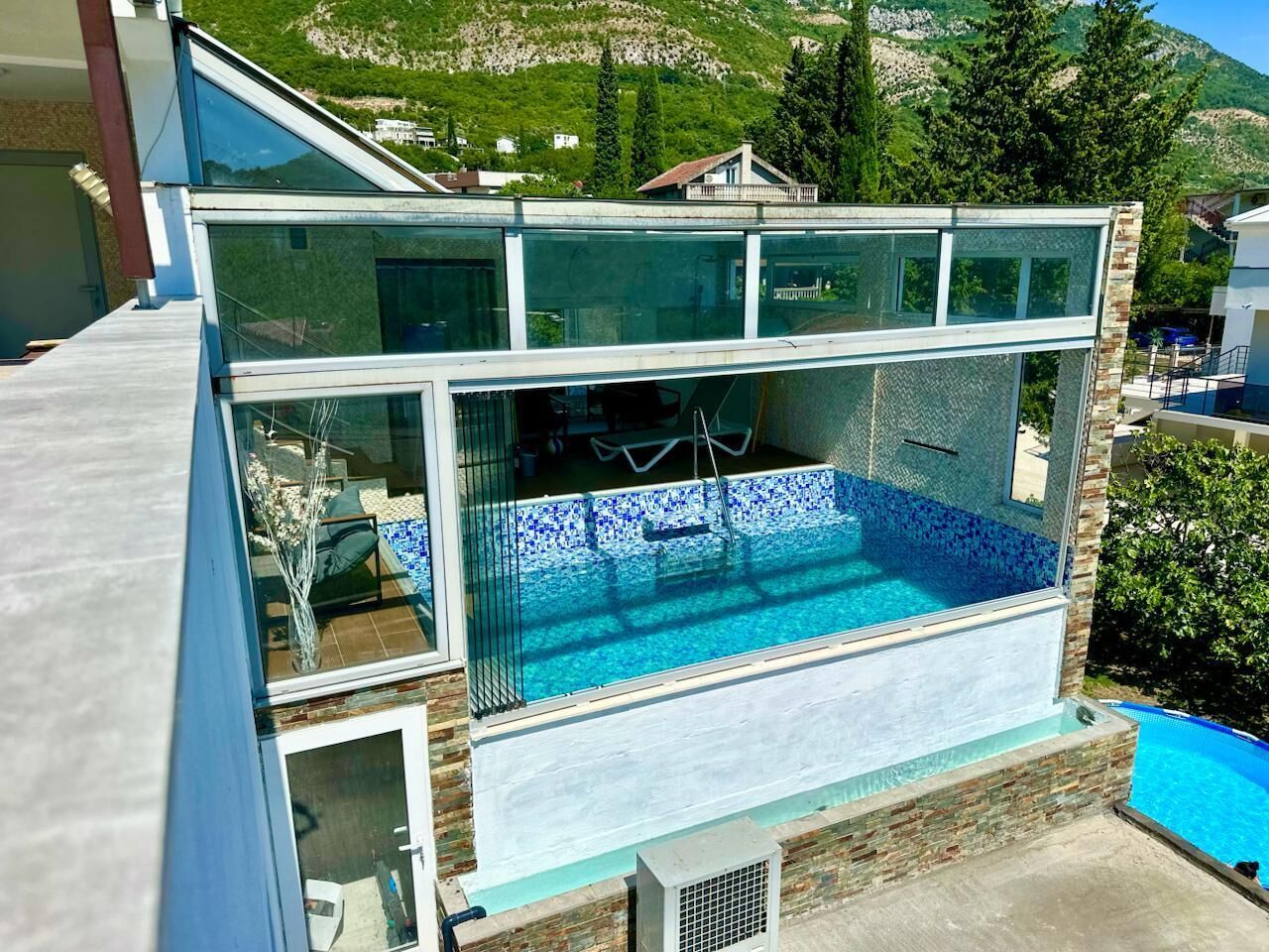 A modern building with a glass-enclosed swimming pool.